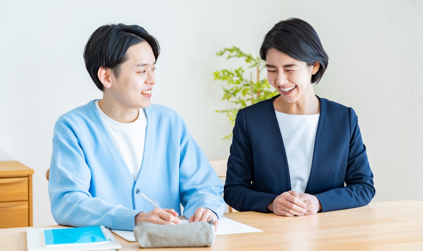 エイトステップスの教室で、生徒と担任の先生が笑顔で面談している様子
